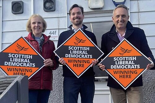 Susan Murray, Adam Harley and Alex Cole-Hamilton holding orange diamonds