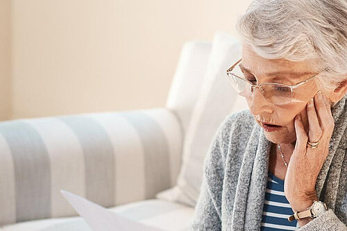 A lady looking at her bills.