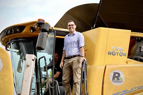 Tom Gordon MP stood on a combine harvester.
