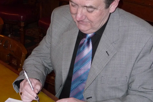 Cllr Alan Lewis writing a cheque for the Mayor's Benevolent Fund