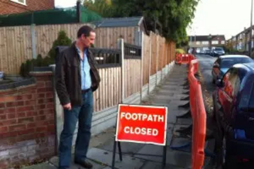 Cllr. Mark Springett looking at broken pavements