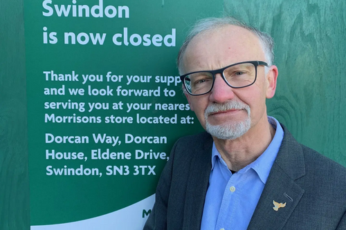 Councillor Stan Pajak standing next to the Morrisons closure sign