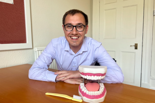 Tom Gordon MP Sat with model of teeth and toothbrush
