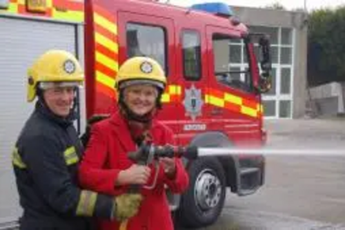 Terrye Teverson with a Falmouth Fireman outsude Falmouth Fire Station