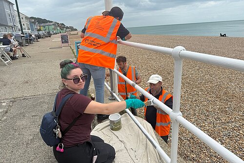 Volunteers painting seafront railings in Sandgate