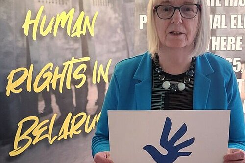 Beatrice Wishart holding a Human Rights sign