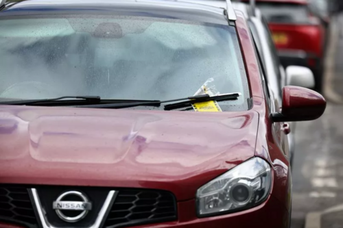 Parking ticket on the windscreen of a parked car