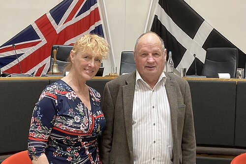 Councillors Hilary Frank and Jim Candy stand in front of the British and Cornish flags