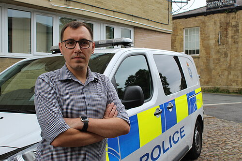 Tom Gordon MP in front of a police van