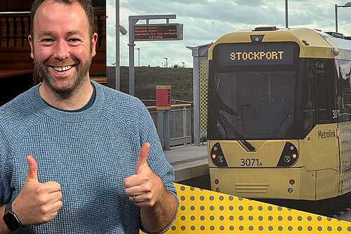 Cllr Mark Roberts, in front of a tram with Stockport on the front