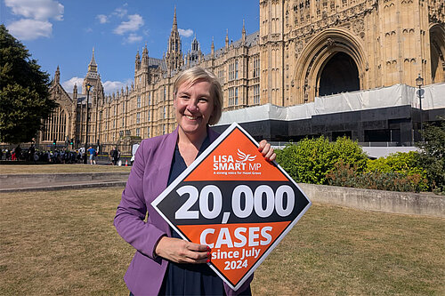 Lisa Smart MP with a 20,000 cases poster
