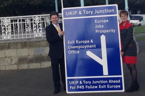 Lynne Beaumont and Antony Hook in Folkestone with road sign to prosperity or Euro exit and Unemployment