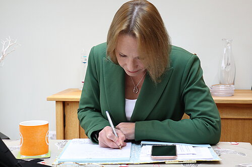 Helen Morgan at her desk writing a letter