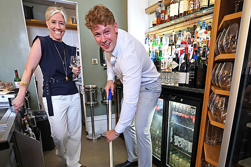 Cllr Carl Cashman is mopping and Daisy Cooper MP is holding a glass of wine