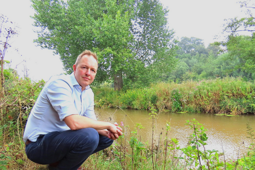 A photo of Richard Foord crouched down by the river Otter
