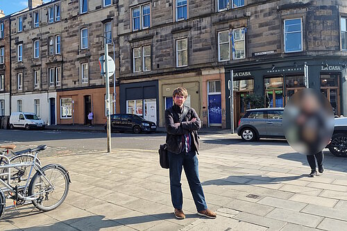 Councillor Jack Caldwell standing in front of a crossing on Dalmeny Street with cars in the background.