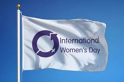 International Women’s Day flag, representing the recognition of women’s achievements and inequalities affecting women and girls.