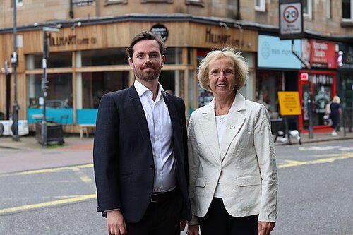 Adam Harley and Susan Murray standing together with local high street businesses in the background