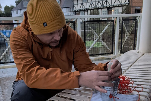 Cameron Thomas sits beside the River Avon at Tewkesbury helping to test water quality