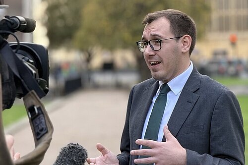 Tom Gordon stood in front of the Houses of Parliament